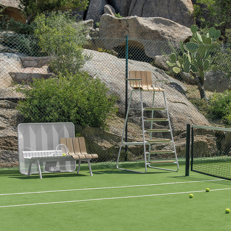 Court de tennis avec chaise d’arbitre et banc de la collection Ace dans un cadre sportif en plein air